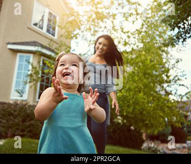 Shes always eager to play outside. a mother bonding with her adorable little daughter outside. Stock Photo