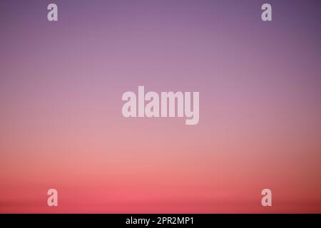 Sunset sky gradient from red to purple, copy space. Clear sunset sky with the bright light of the setting sun Stock Photo