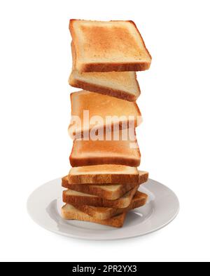 Delicious toasted bread falling into plate on white background Stock Photo