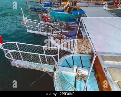 yacht in the open sea. ships are moored to the shore. boats with tourists are in the port. on the yacht rubber protection rings, grille and seating. Stock Photo