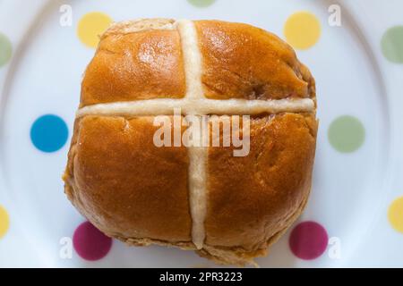 Banoffee hot cross bun, banana & Caramel fudge from M&S on spotty plate - filled with salted caramel fudge pieces and banana purée Stock Photo