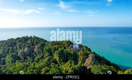 This aerial view captures the stunning Tanjung Tuan Lighthouse perched atop a lush green cliff in Malacca, Malaysia Stock Photo