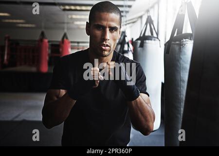 Fall seven times, stand up eight. a kick-boxer training in a gym. Stock Photo
