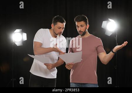 Professional actors reading their scripts during rehearsal in theatre ...
