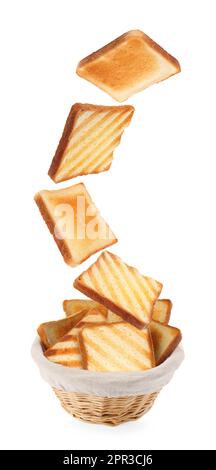 Delicious toasted bread falling into basket on white background Stock Photo