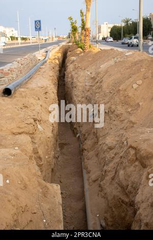 pipe laying trench with plastic pipe in the desert Stock Photo