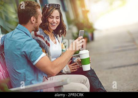 What do you think of my selfie. a happy young couple using a smartphone together while spending the day downtown. Stock Photo