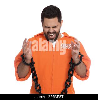 Emotional prisoner in jumpsuit with chained hands on white background Stock Photo