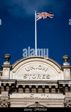 British Union Jack flag flying above a Victorian warehouse in Oamaru, North Otago, South Island, New Zealand Stock Photo