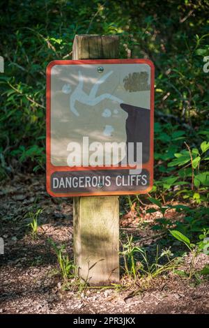 Prohibited Sign Yellow Caution sign stands on a wooden walkway inside a stone passage Stock ...