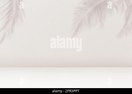 Product placement background with palm leaves shadow on beige cement wall texture. Empty palm shadow brown color pattern on wall background. Summer tr Stock Photo
