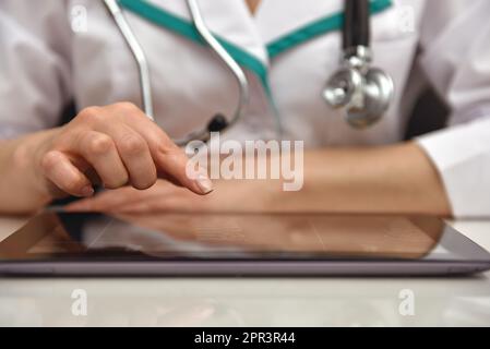 Female Doctor Examines X-ray Of Patient On Tablet. Close Up Stock Photo