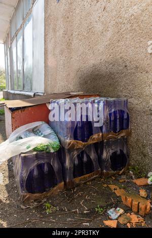 Grodno, Belarus - 20 April, 2023: Cardboard packages with empty bottles of Lidskoe Ideal beer are in the backyard of the building. Stock Photo