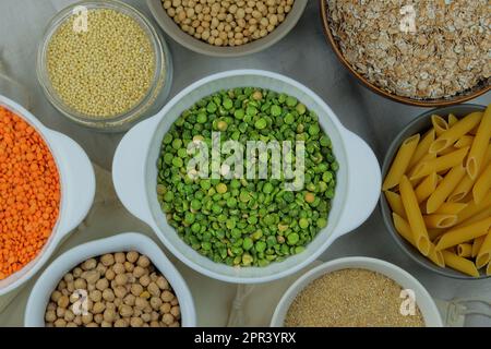 Green pea in bowl on a straw background. Vegetarian organic product. Vintage view. Top view. Stock Photo