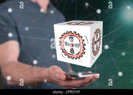 Business process concept above a smartphone held by a man in background Stock Photo