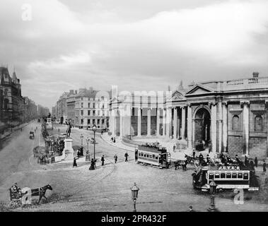 A late 19th century photograph of College Green in the centre of Dublin, Ireland. On its northern side is the Bank of Ireland building, which until 1800 was Ireland's Parliament House. It was originally constructed by Arthur Chichester, 1st Baron Chichester in the early 17th century and later adapted for the Irish Parliament around 1670. It was replaced by a new Parliament House in 1729, designed by Edward Lovett Pearce, it was later enlarged by James Gandon in 1787 and Edward Parke between 1804 and 1808. The site is now the Bank of Ireland. Stock Photo