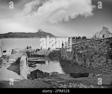 A late 19th century photograph of Coliemore Harbour, also known historically as Dalkey Harbour in County Dublin, Ireland. The harbour developed strategic value as a port for bulk shipments bound for Dublin during the 15th century. The channel between Dalkey Island with its Martello Tower and the mainland provided ideal conditions for unloading galleons carrying heavy cargo due to its depth (relative to Dublin Bay) and its sheltered position. The treacherous shallows of Dublin Bay prevented direct shipments into the city center, making Dalkey an ideal access point for trade. Stock Photo