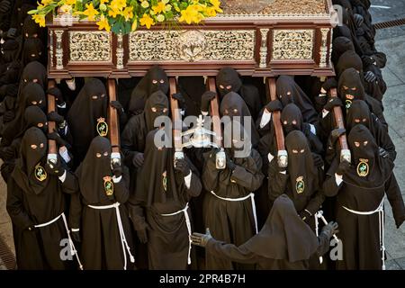 A group of black hooded monks carrying a funeral casket in Astorga, Castilla y Leon, Spain Stock Photo