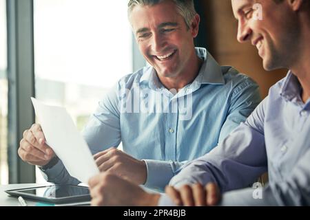 Im really impressed with this work. two businessmen discussing paperwork while sitting in an office. Stock Photo