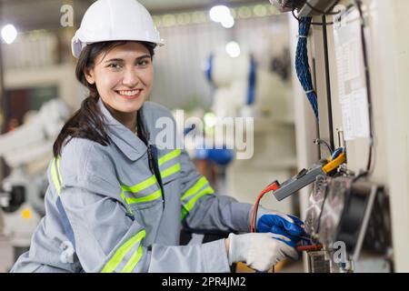 electricity engineer female working check service high voltage electrical cabinet. worker repair electric surge problem problem in industry factory. Stock Photo
