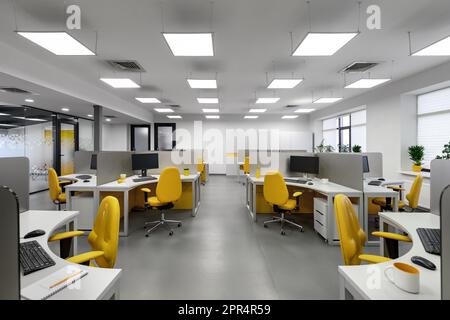 It office with workplaces for employees developers with yellow chairs and computers. Stock Photo