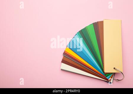 Colored cardboard palette, paper catalog on a pink background. Top view. Stock Photo