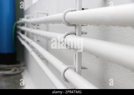 Water supply new plastic pipes of white color on the wall of the house Stock Photo