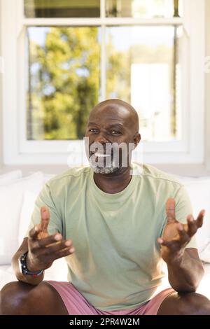 Portrait of happy senior african american man having video call and gesturing Stock Photo