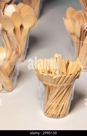 Eco-friendly disposable kitchen utensils, bamboo skewers in a plastic cup. Ecology, zero waste concept. Stock Photo