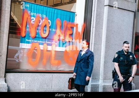 New York, United States. 24th Apr, 2023. An activist with UK-based Extinction Rebellion is accosted by Citibank's security for spraying 'No New Oil' on the bank's exterior. Climate activists with Extinction Rebellion graffiti Citibank's branch in New York with chalk ahead of the bank's annual shareholder meeting in New York on Monday April 24, 2023. Two shareholder resolutions are expected tomorrow aimed at holding the bank accountable to its commitments on climate change and indigenous rights. (Photo by Olga Fedorova/SOPA Images/Sipa USA) Credit: Sipa USA/Alamy Live News Stock Photo