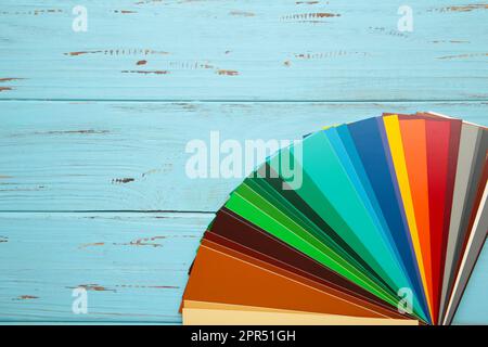 Colored cardboard palette, paper catalog on a blue background. Top view. Stock Photo