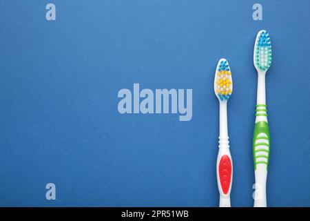 Two toothbrushes on blue background with copy space. Top view Stock ...