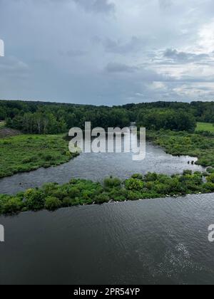 A tranquil body of water surrounded by lush grass in a shallow area ...