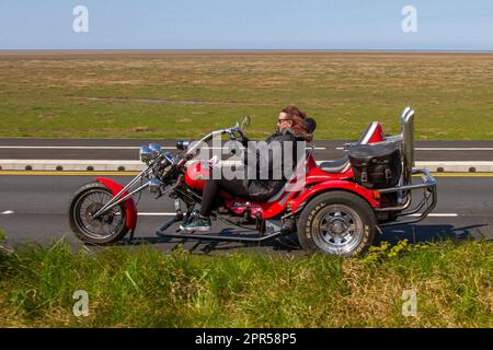 Side View of Red Glimmer Rewaco trike HS4 2003 1600cc ; travelling on the seafront Marine Drive, Southport, UK Stock Photo