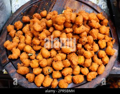 Tasty Pakora aka Pakoda. Indian Deep Fried Street Food on Sale. Stock Photo