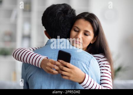 Pretty young eastern woman chatting while hugging her boyfriend Stock Photo
