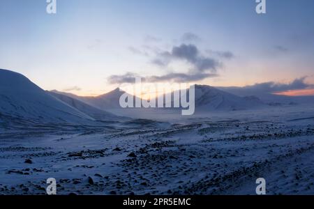 Close to the toe of the Langjökull ice cap. A frozen, snow and ice covered landscape in the west of the Icelandic interior at dusk after sunset. Stock Photo