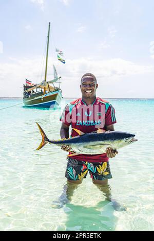 Portrait of happy fisherman showing the catch of fish, Zanzibar, Tanzania Stock Photo