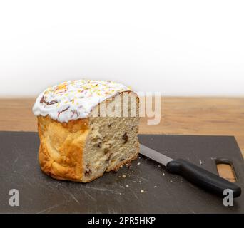 Traditional Ukrainian Easter food,Paska, iced fruit bread. Also Kulich in Russian tradition. Bread knife on chopping board. Stock Photo