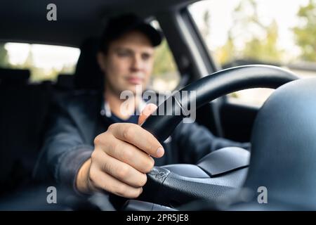 Man driving car. Driver in summer. Taxi cab chauffeur. Traffic insurance or commute concept. Happy young person working in vehicle dealership. Stock Photo