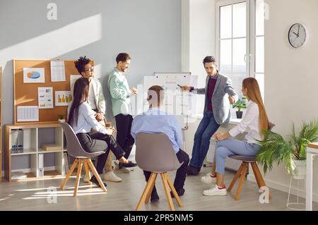 Professional manager, business coach or team mentor having a meeting with a group of people Stock Photo
