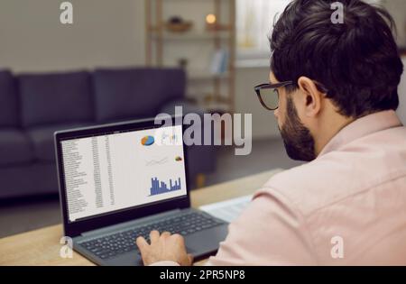 Focused businessman working with analytics using laptop sitting at workplace Stock Photo