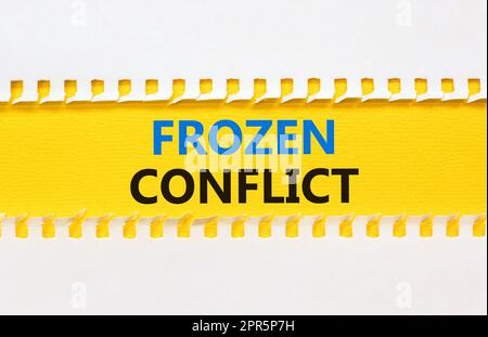 Frozen conflict symbol. Concept words Frozen conflict on beautiful yellow paper. Beautiful white table white background. Business and Frozen conflict Stock Photo