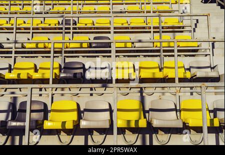 Yellow chairs in stands of a sports institution. Empty stands of the stadium Stock Photo