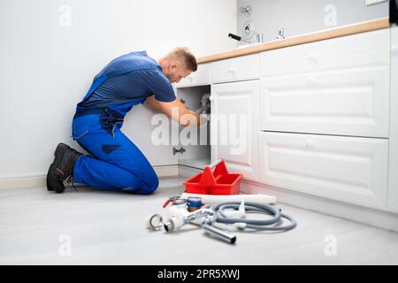 Male Plumber Fixing Sink Pipe Stock Photo