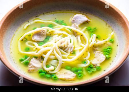chicken broth with green peas and noodles Stock Photo