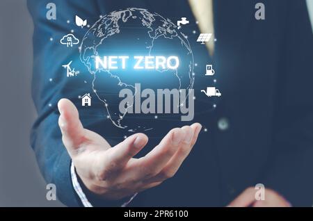 Man hand virtual world icon. NET ZERO icons and symbols save the eco world and reduce pollution virtual screen. Business eco concept. Stock Photo