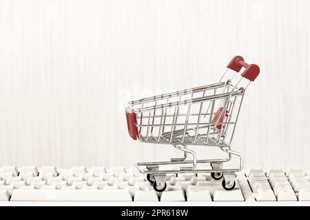 Empty shopping cart on computer keyboard Stock Photo