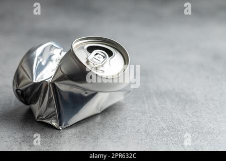 Empty crumpled can on gray table. Stock Photo