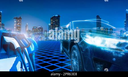 Electric car and EV car charging station at gas station with cityscape background in futuristic vehicle concept. Electric vehicle in smart city at night. Sustainable power. Clean and green energy. Stock Photo